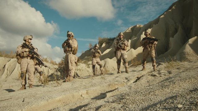 Squad of Fully Equipped and Armed Soldiers Standing in the Desert. Shot on RED EPIC Cinema Camera in 4K (UHD).