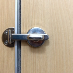 stainless bolt the doors locked of restroom in hotel. Wooden door. Stainless handle for lock toilet room.