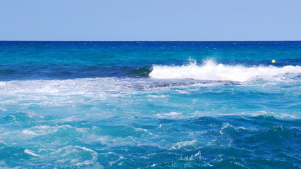 Azure sea breaking waves