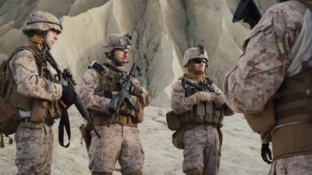 Group of Soldiers are Standing in a Circle and Listening Orders from Commander During Briefing before Military Operation in the Desert. Slow Motion.