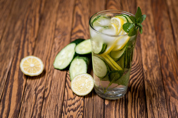 Water with lemon, mint and cucumber on wooden background. Water Detox.
