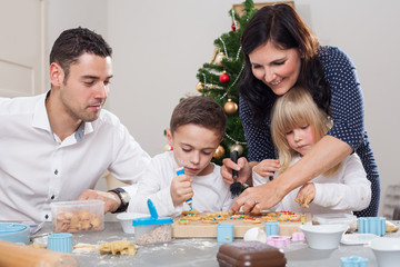 Obraz na płótnie Canvas family decorates christmas cookies