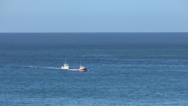 Fisher boat get towed in from the open sea in the harbor after a broken engine.