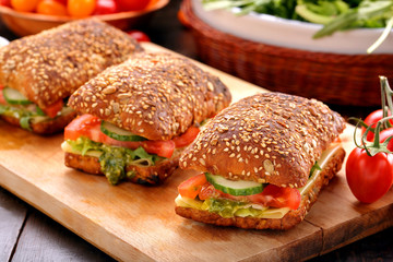 Vegetarian sandwich with pesto on wooden background
