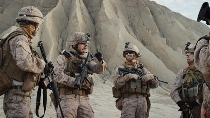 Group of Soldiers are Standing in a Circle and Listening Orders from Commander During Briefing before Military Operation in the Desert. Slow Motion.