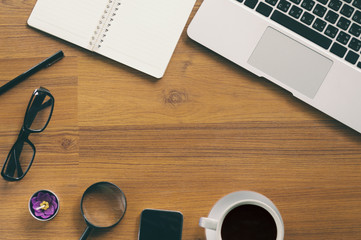 Office wooden table with notepad, laptop and coffee cup.View from above with copy space.Concept ideas.