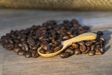 abstract sun light on coffee beans in wood spoon