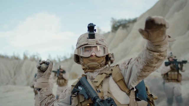 Soldier Throwing a Granade during Combat in the Desert. Slow Motion.