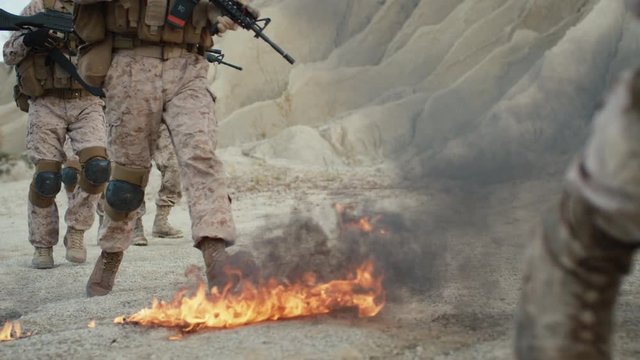 Close-up Shot of Soldiers Walking on Burning Ground in the Desert. Slow Motion.