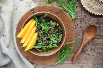 Organic salad with quinoa, arugula and mango. View from above