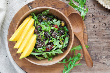 Organic salad with quinoa, arugula and mango. View from above