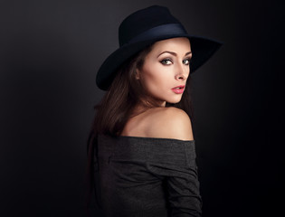 Expressive makeup woman in fashion elegant hat posing on dark shadow background. CLoseup portrait