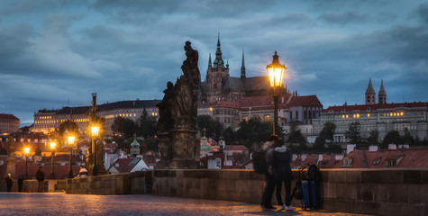 Obraz premium Prague Castle and Charles Bridge in the night with people on it.