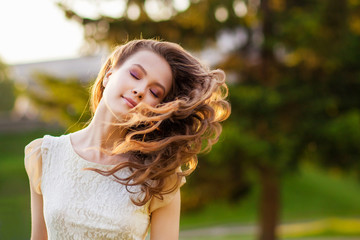 Naklejka premium Girl at sunset with flying hair