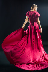 Back view of young blonde woman in bright pink dress