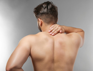 Man with neck pain on grey background