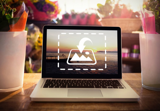 Laptop on Wooden Table Surrounded by Flower Vases Mockup