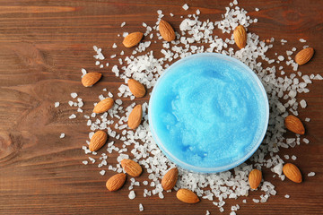Body scrub, almond and salt on wooden background