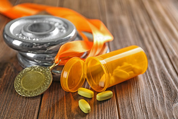 Drugs, medal and weight disks on wooden background