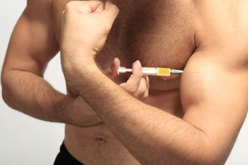 Muscular man injecting steroids, closeup