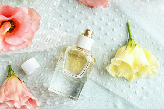 Composition of perfume bottle and flowers on light background