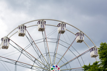 Ferris wheel on a background cloudy sky