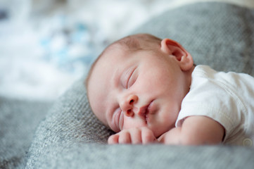 Newborn baby boy lying on bed, sleeping, close up