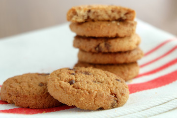 Chocolate chip cookies on white linen napkin on wooden tab