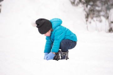 Fototapeta na wymiar Cute little boy playing outside in winter nature