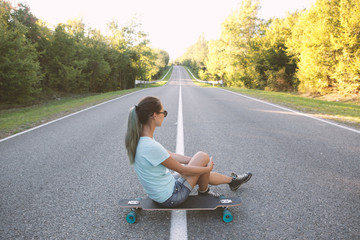 Girl sitting on a longboard.