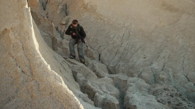 Armed Terrorist Walking in Desert Environment
