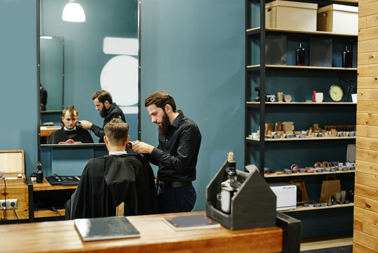 Male Hairdresser Cuts Client Electric Clippers In The Barbershop