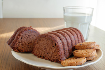 Chocolate Loaf cake, cookies and milk on a plate
