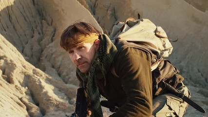 Close-up Shot of Armed Terrorist Walking in Desert Environment