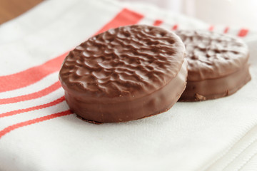 Chocolate cookies on white linen napkin on wooden