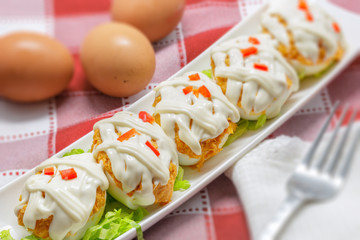 Stuffed eggs with tuna, tomato, mayonnaise and red pepper on red