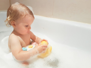 little 1,5 year-old baby boy playing in bath