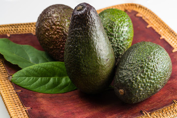Green fresh avocado with leaves