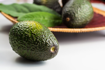 Green fresh avocado with leaves