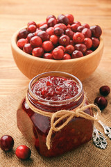Cranberry jam on brown wooden background.