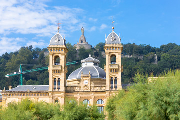 Naklejka premium Towers of the city hall of Donostia San Sebastian. The city council is located in the premises of the former casino of the city. In the background on the mountain Urgull, the sculpture of Jesus Christ