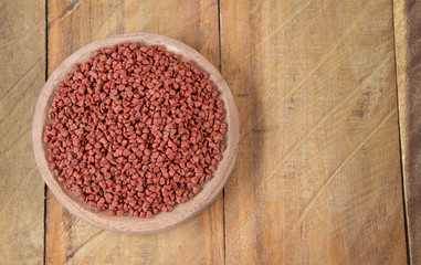Obraz na płótnie Canvas Annatto seeds in wooden bowl