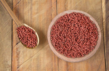 Annatto seeds in wooden bowl