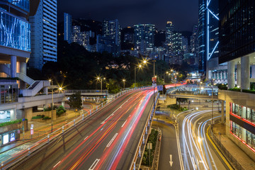 Fototapeta na wymiar View of light trails on the Cotton Tree Drive road and high-rise apartment buildings in Mid-Levels on the Hong Kong Island in Hong Kong, China, at night.