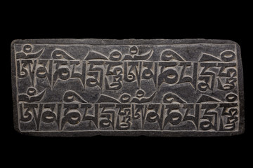 Tibetan Mani-Stone against black background
