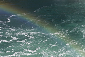 Beautiful background with the water near amazing Niagara falls with a rainbow