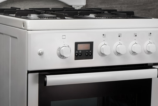 Close up of clean white kitchen gas stove on gray