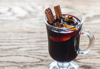 Glass of mulled wine on the wooden background