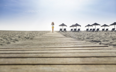 Fototapeta na wymiar Woman with hat on the beach