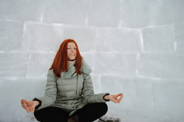 Young girl sitting in the frosty hut
